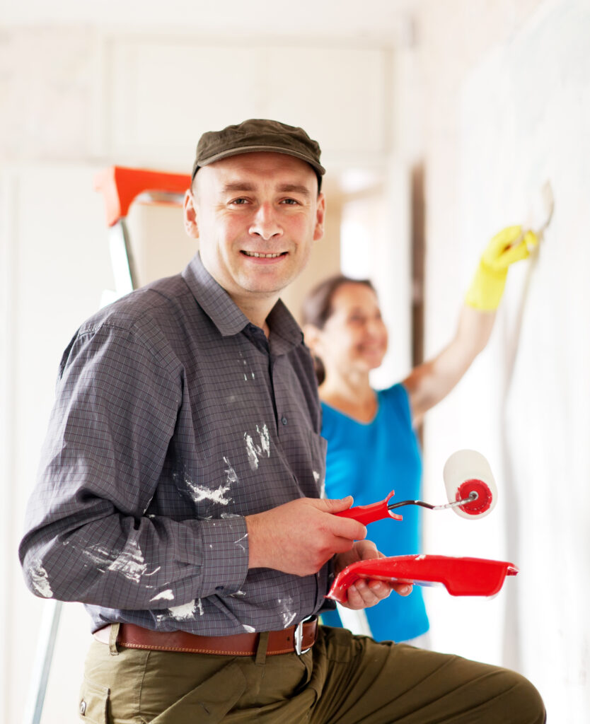 Man and woman paints wall