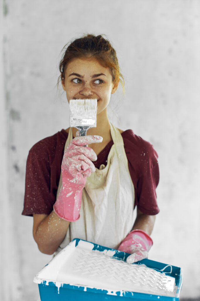 woman painter with brush paints in room decoration home renovation